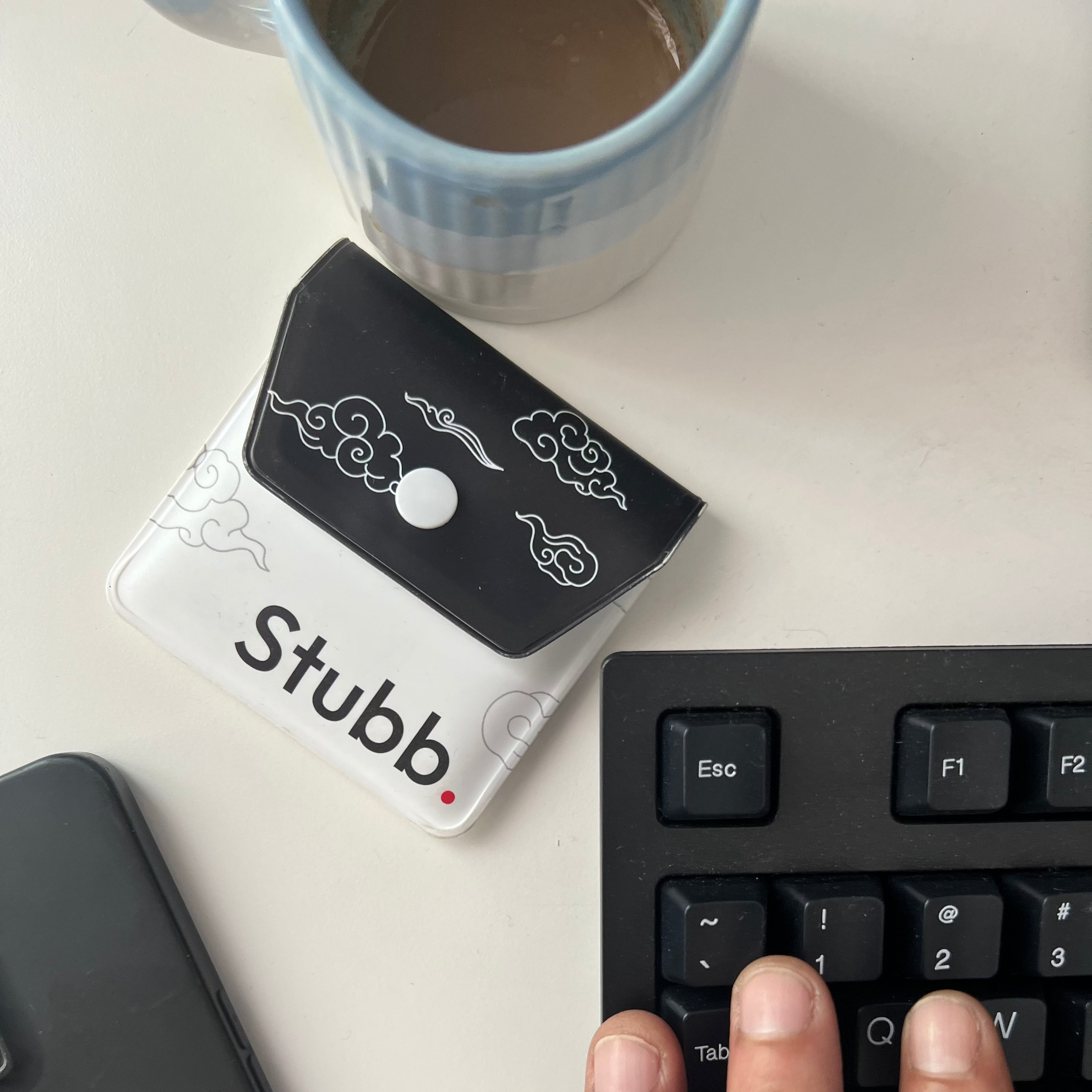 Stubb pocket ashtray on a desk with a keyboard and mug
